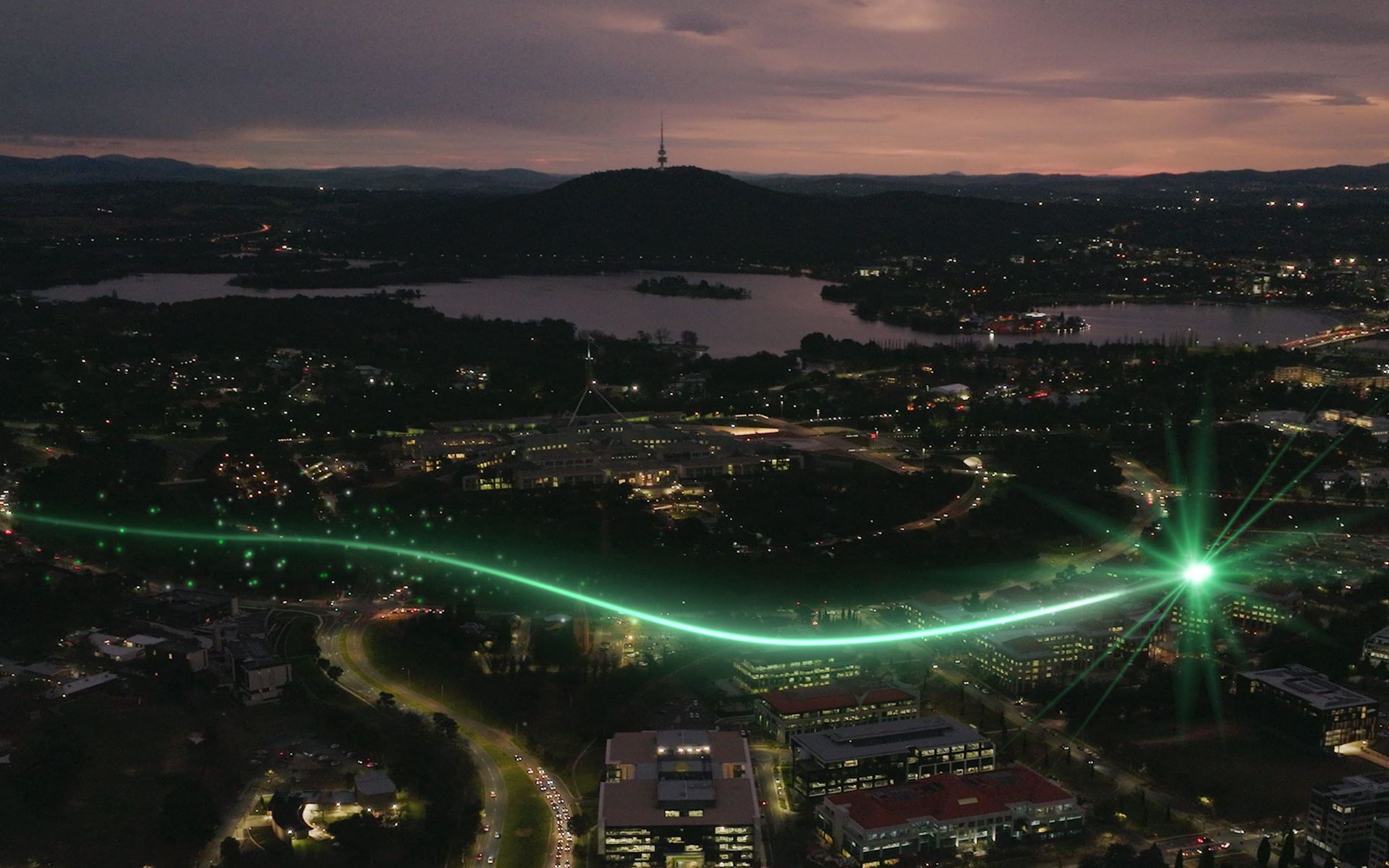 An aerial view of Canberra at night with a green light