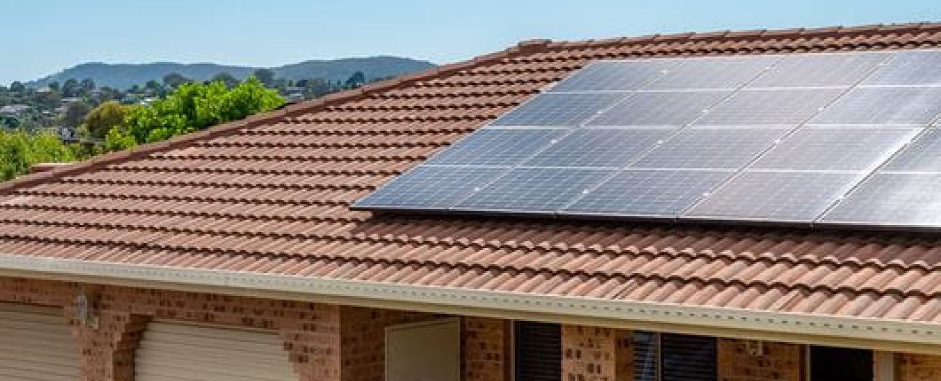 Single storey house with terracotta roof tiles and solar panels