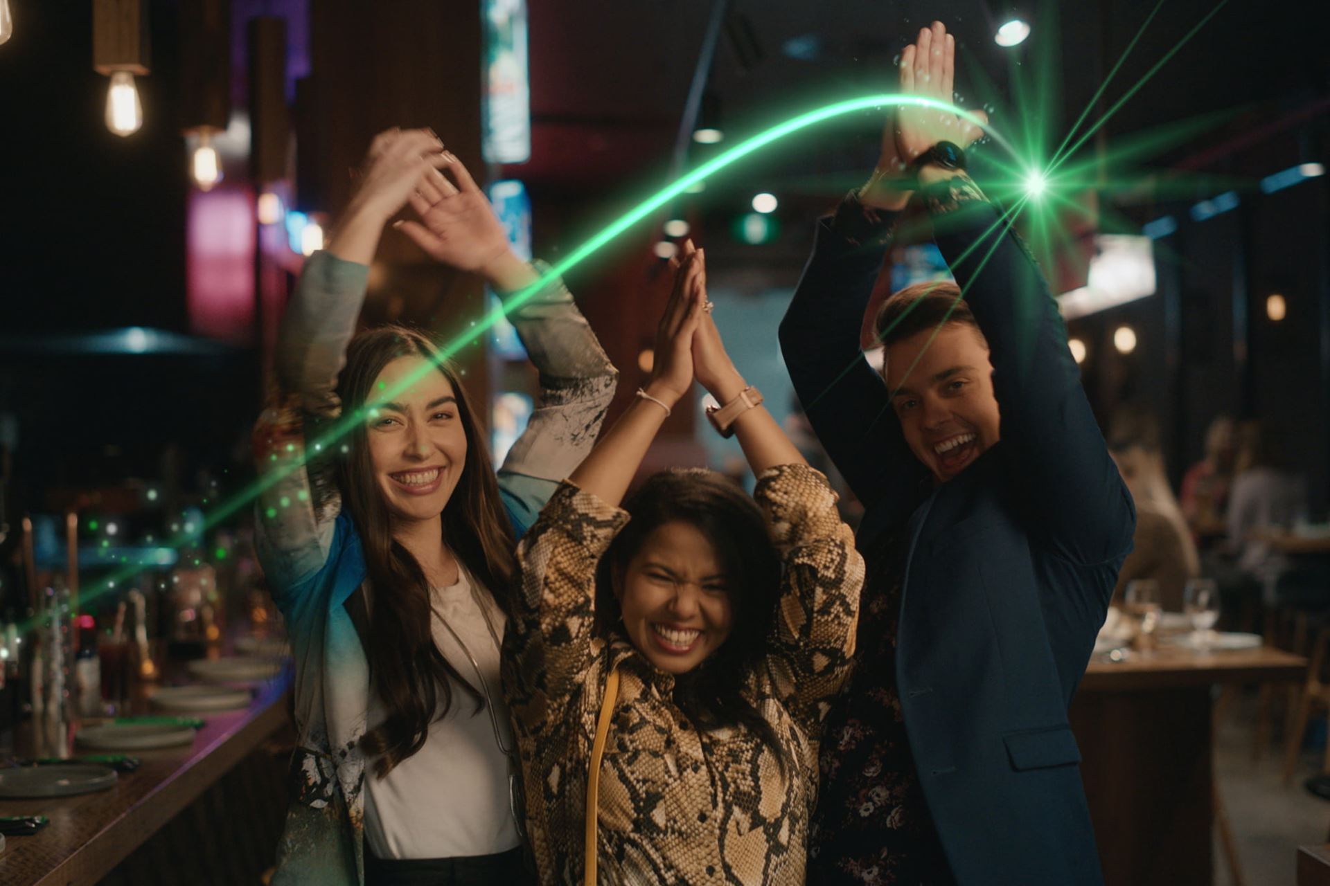 Three young people with hands in the air clapping