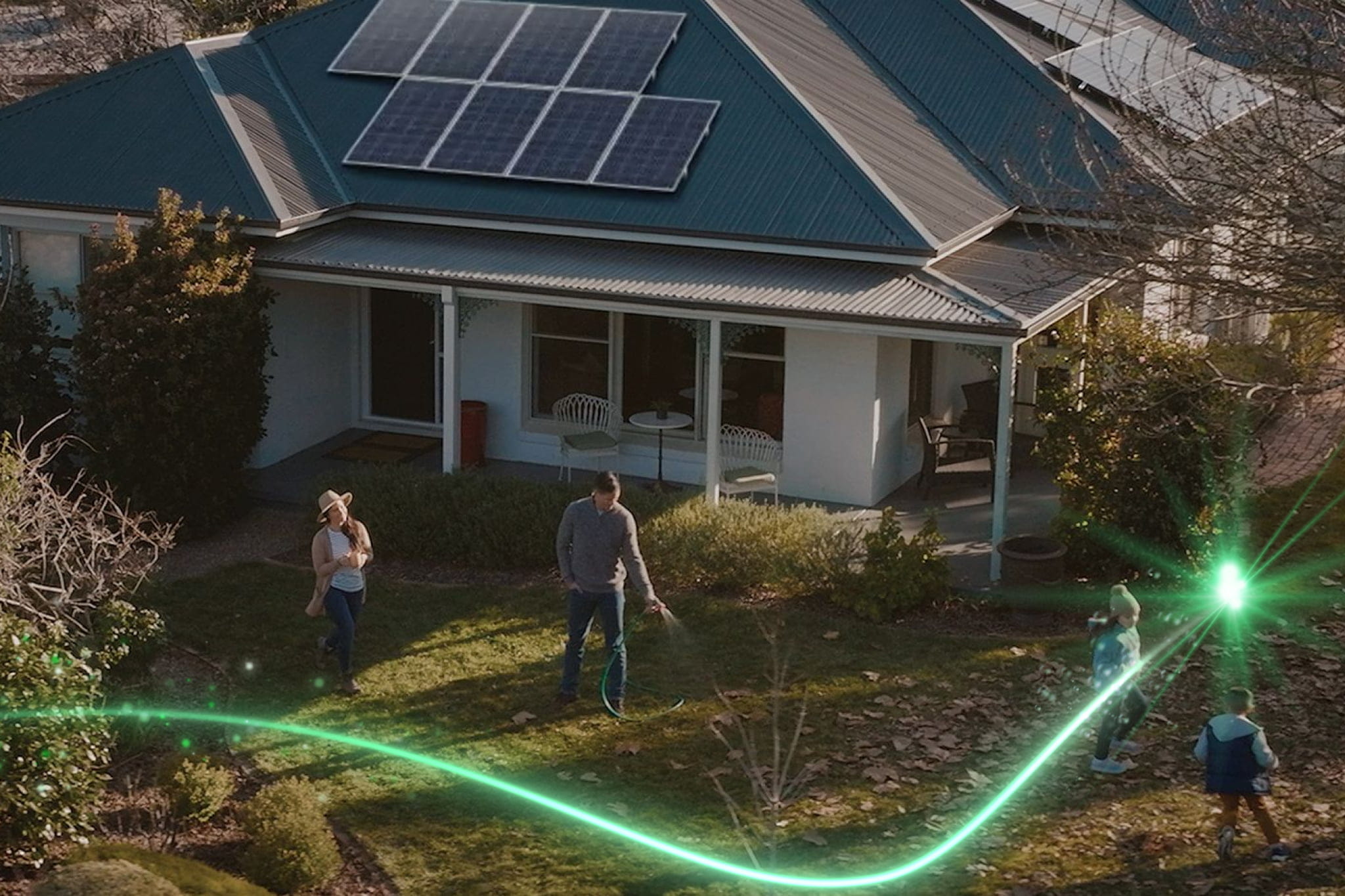 A couple watering the garden in front of their house