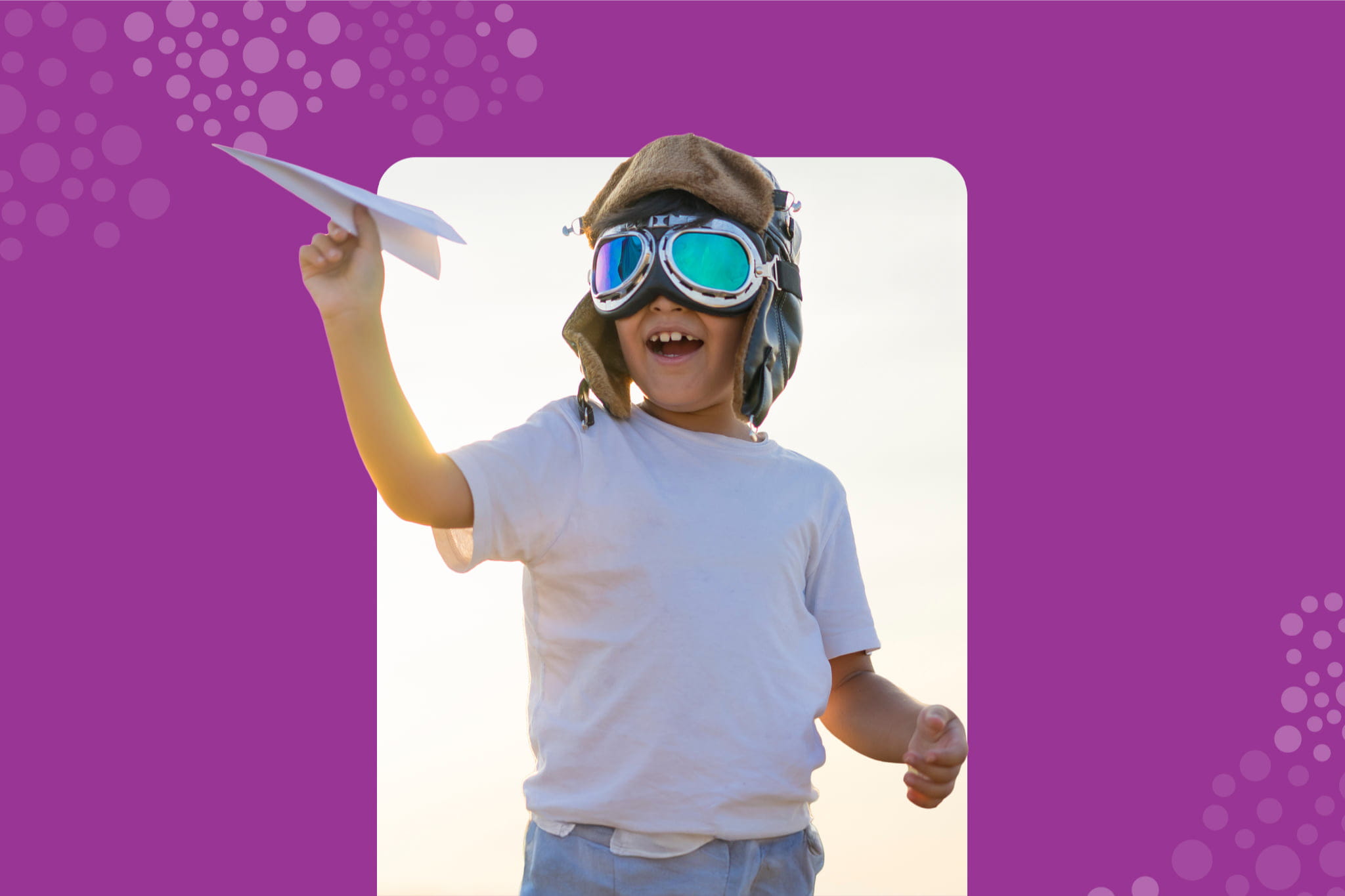 a kid wearing hat and goggles playing with paper plane