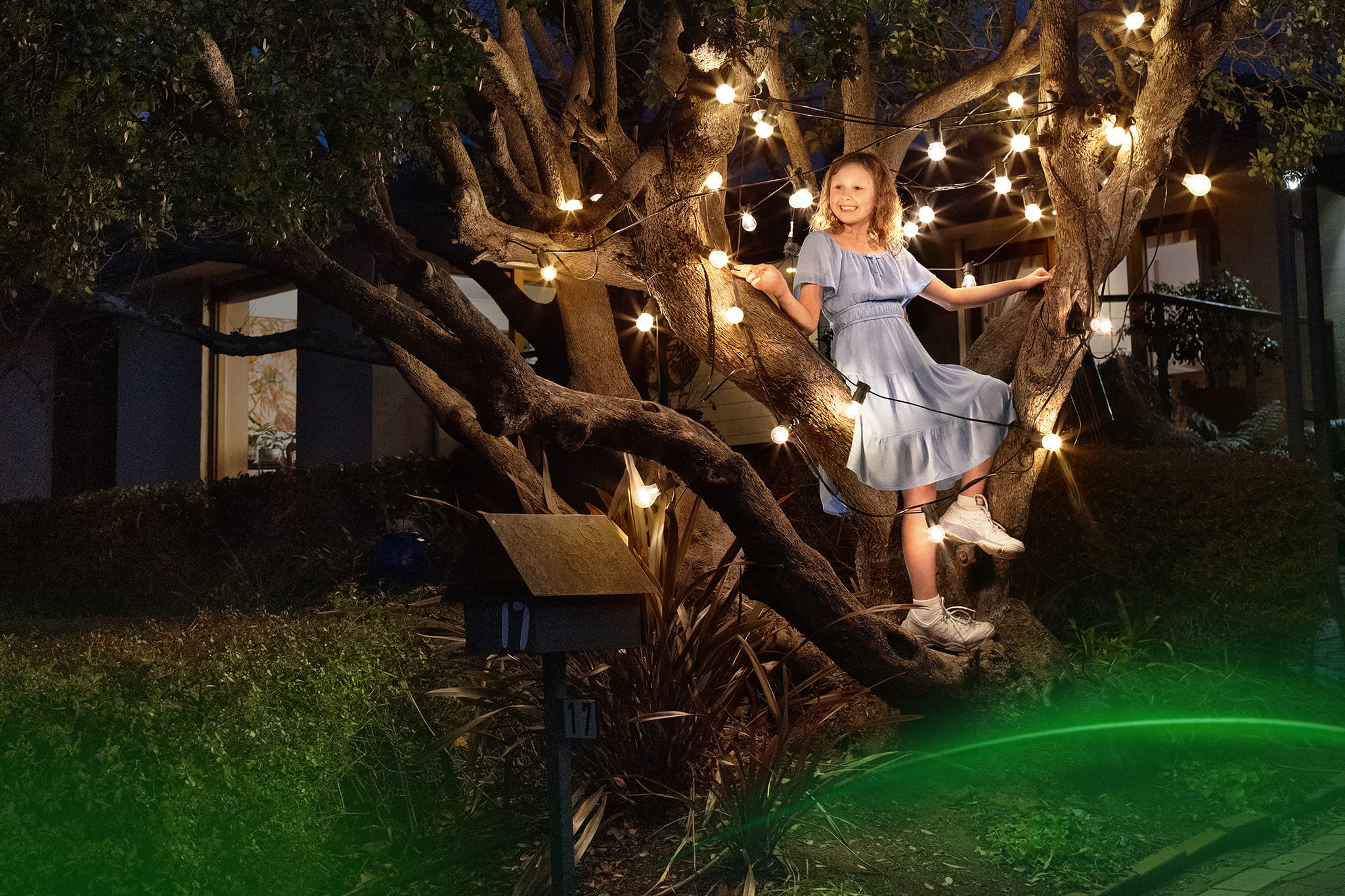 The energy for around here girl in tree with festoon lights