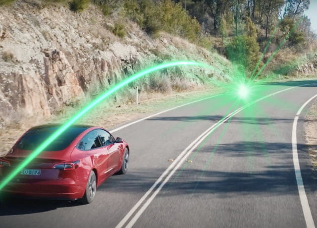Red Tesla cruising down a highway