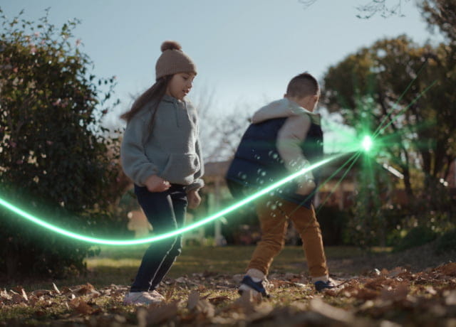 A girl and a boy playing in the park with green streak