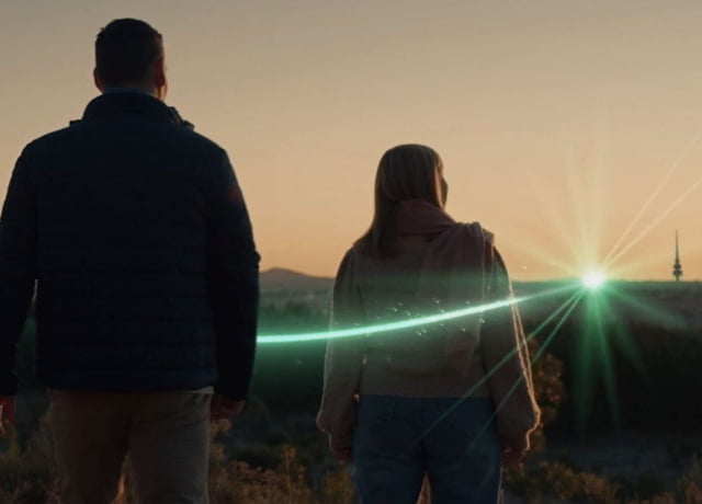 A man and a women standing and looking at the mountains 