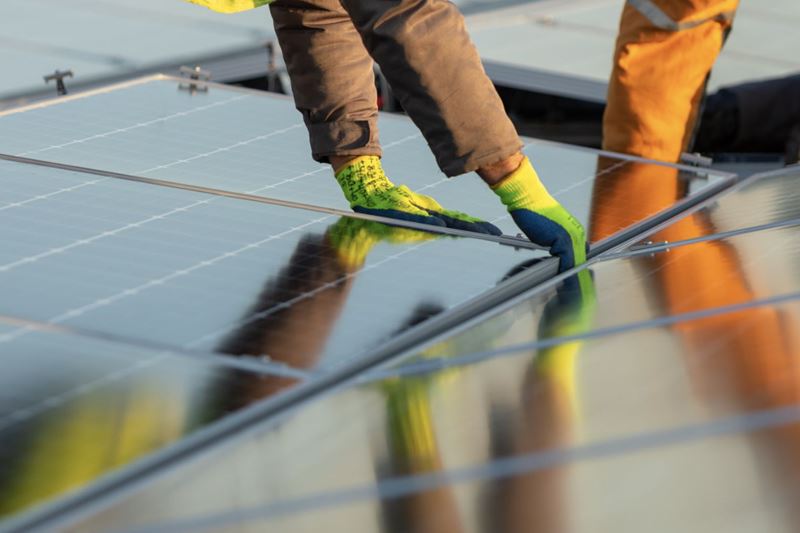 A worker installing rooftop solar panels