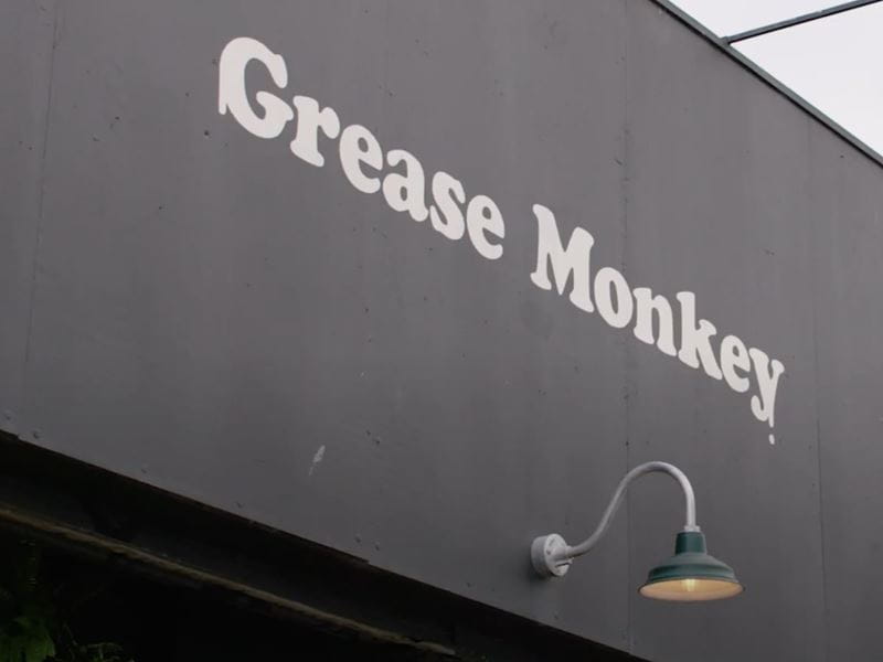 Grease Monkey logo visible on the side of a building