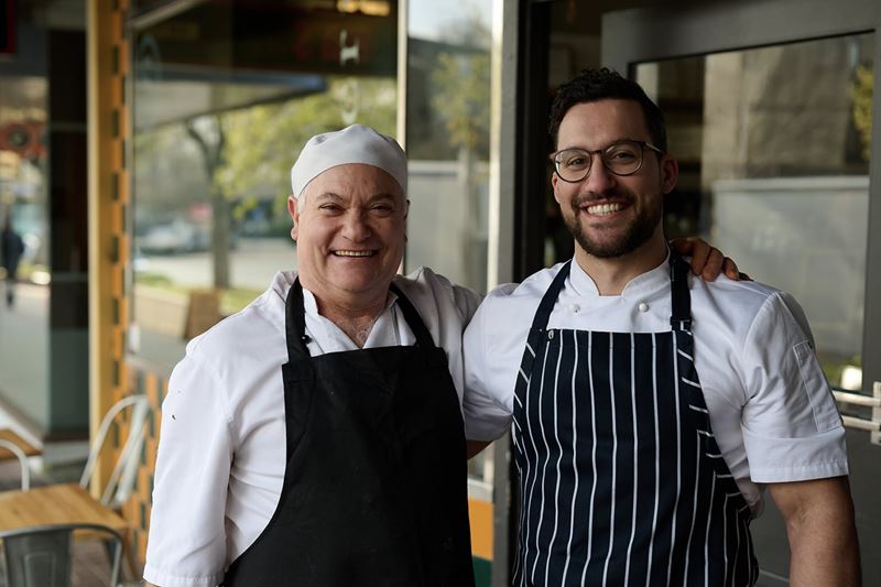 Two chefs happily standing in front of their small business