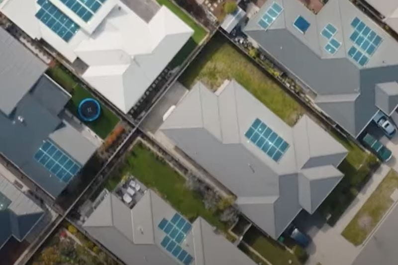 An aerial view of a suburb featuring solar panels on rooftops