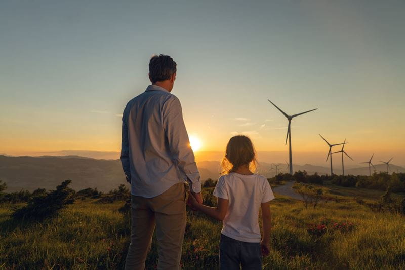 Father and daughter looking at solar windmill