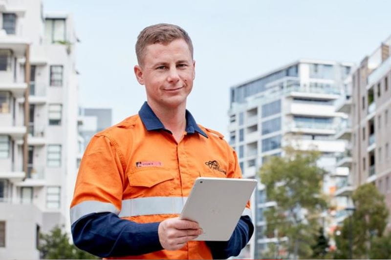 A man dressed in a hi-vis shirt holding a tablet