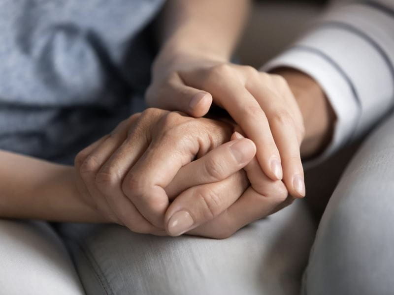 Two people holding hands to support each other