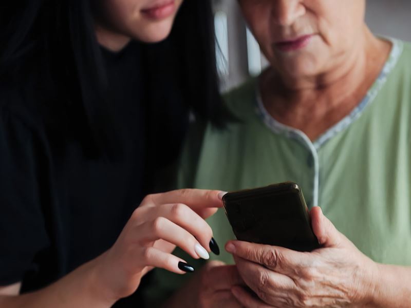Two women scrolling on a smartphone