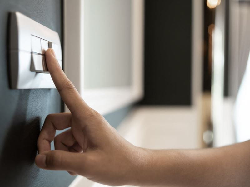 A light switch being turned off by someone's hand 