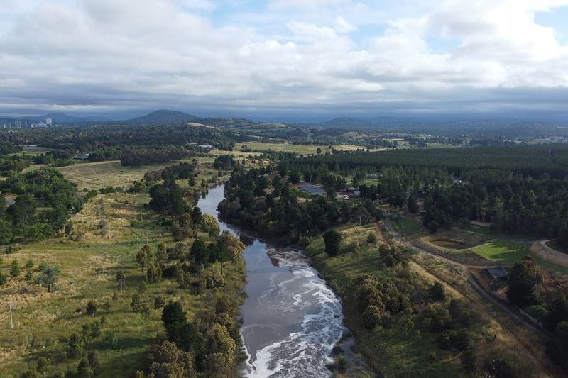 Drone shot of a river running through a lush green valley