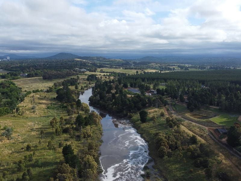 Aerial view capturing a river running through a lush green valley
